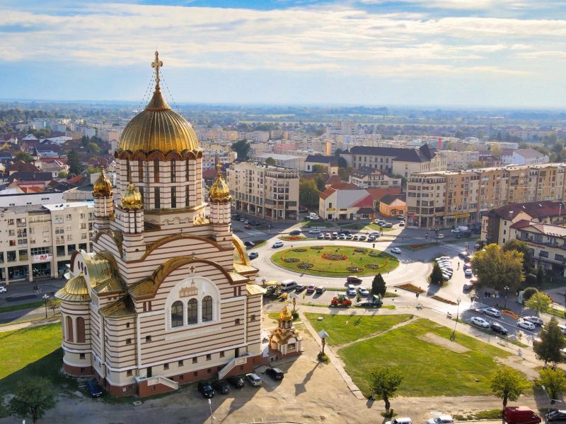 Aerial drone view of the Fagaras, Romania. Church of the Saint John the Baptist, buildings, roads with cars, greenery
